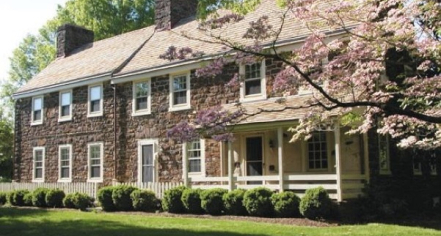 Image Of A Brown Stone Building With A Tree With Pink Blossoms In The Foreground.